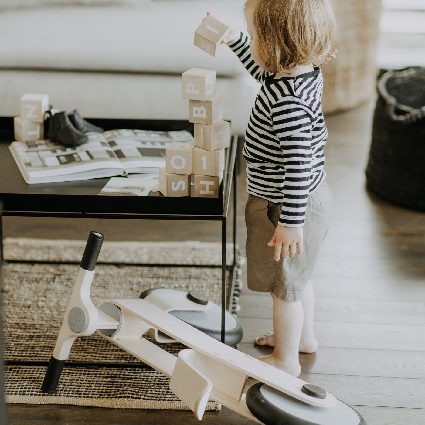 Toddler next to a wooden balance bike showing correct bike size